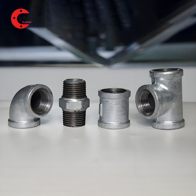 Set of galvanized malleable iron pipe fittings, including 90° elbow, nipple, coupling, and tee, threaded connections for low-pressure plumbing, gas, and industrial piping systems.